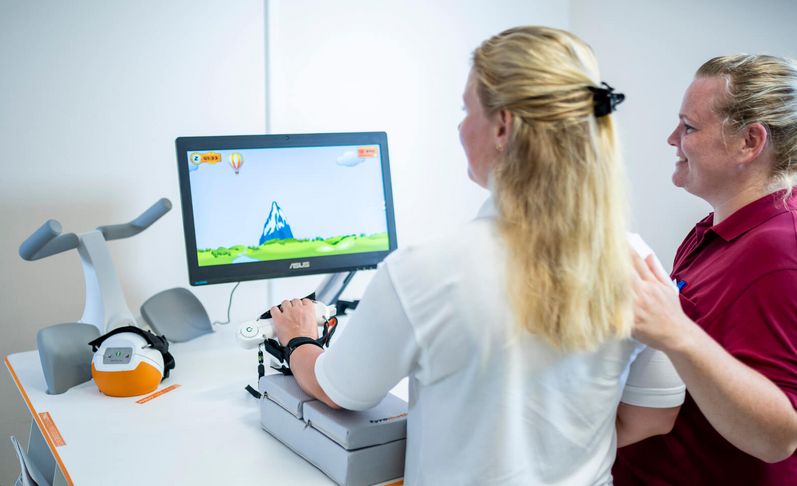 Patientin übt in der Physiortherapie an der Tyrostation