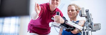 Therapeutin trainiert Patientin im Armlabor
