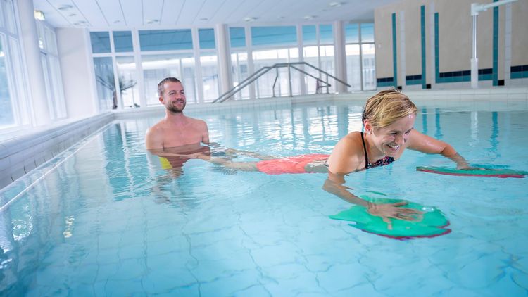 Therapeut und Patient trainieren im Schwimmbad