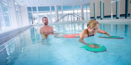 Therapeut und Patient trainieren im Schwimmbad