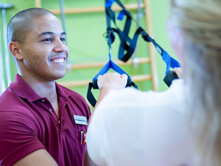 Therapeut behandelt Patientin in der medizinischen Trainingstherapie