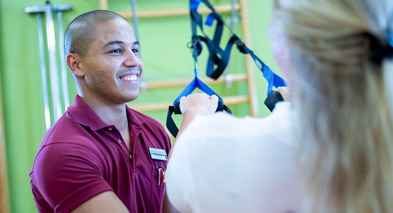 Therapeut behandelt Patientin in der medizinischen Trainingstherapie