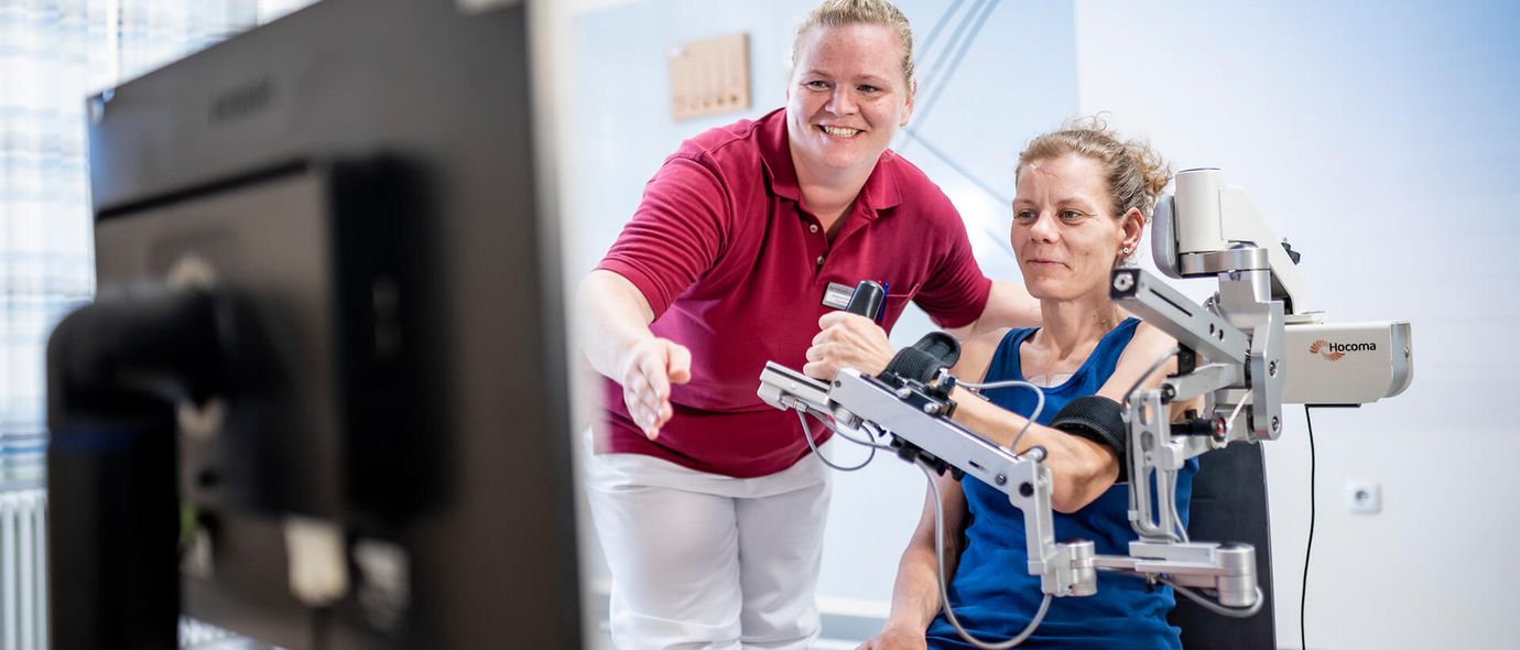 Therapeut unterstützt Patienten beim Armtraining
