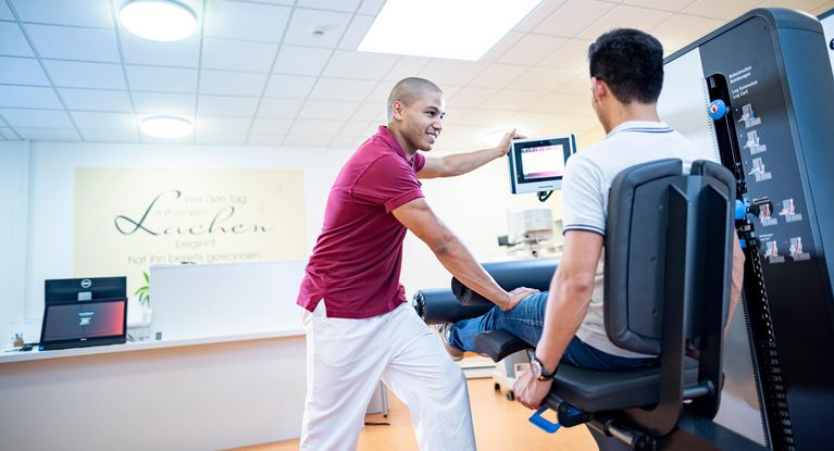 Medizinische Trainingtherapie Therapeut unterstützt Patient in der Medizinische Trainingtherapie