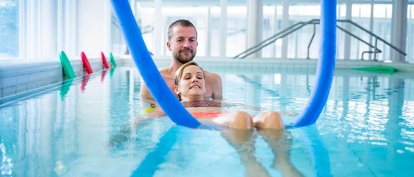 Therapeut und Patient trainieren im Schwimmbad