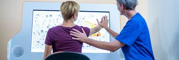 Therapeutin behandelt Patient in der computergestützten Therapie